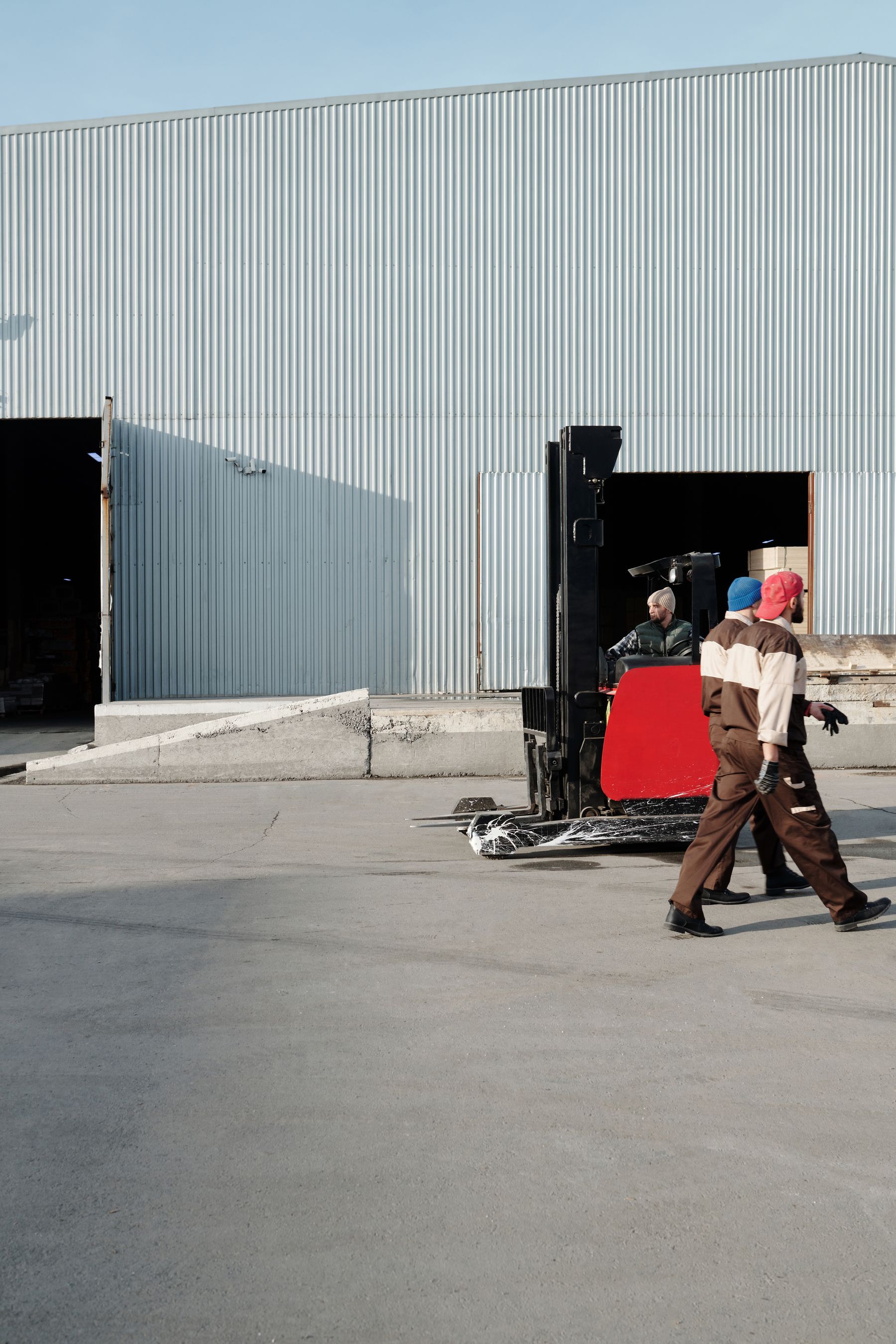 Forklift and warehouse workers outside a loading entrance